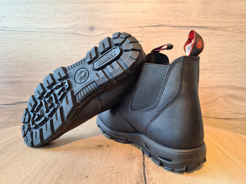 Redback Lederboots mit markanter Profilsohle auf einem Holzboden